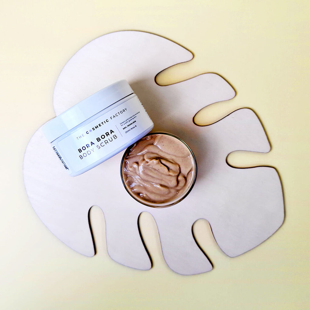 Bora Bora body scrub with a decorative leaf-shaped container on a yellow background