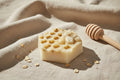 Bar of soap with honeycomb texture on a textured fabric background